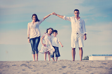 Image showing family on beach showing home sign