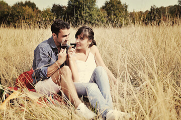 Image showing happy couple enjoying countryside picnic in long grass