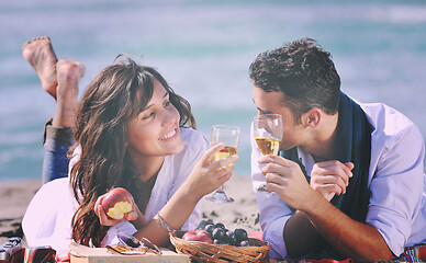 Image showing young couple enjoying  picnic on the beach