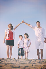 Image showing family on beach showing home sign