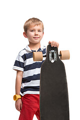 Image showing Full length portrait of an adorable young boy riding a skateboard isolated against white background