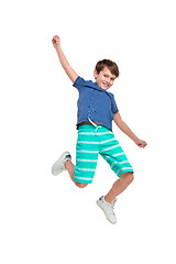 Image showing Adorable boy jumping and raises his hands up.