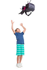 Image showing Full length portrait of cute little kid in stylish clothes jumping with bag