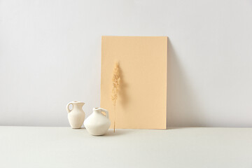 Image showing Eco composition from ceramic vases with dry twig and vertical paper sheet.