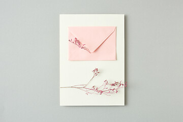 Image showing Holiday card from flower twigs and paper envelope on a light grey background.