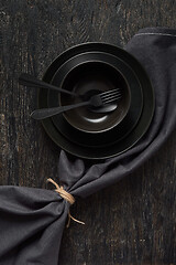 Image showing Served kitchen table with cookware and textile napkin in black colors.