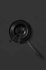 Image showing Set of different cooking empty utensil black colored on the same color background.