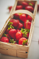 Image showing Fresh healthy strawberries in a wooden box on white background.