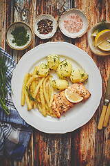 Image showing Fresh and tasty baked salmon served with young boiled potatoes and yellow bean.