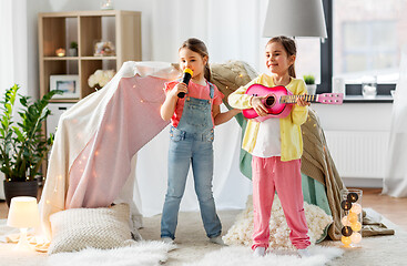 Image showing girls with guitar and microphone playing at home