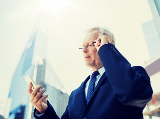 Image showing senior businessman with smartphone in city