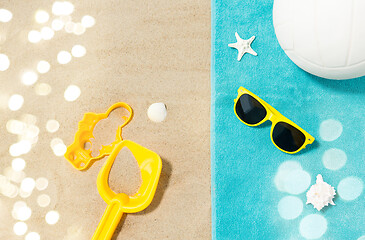 Image showing sunglasses, sand toys and ball on beach towel