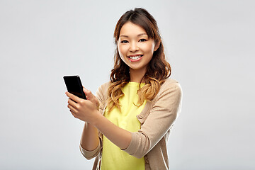 Image showing happy asian woman using smartphone