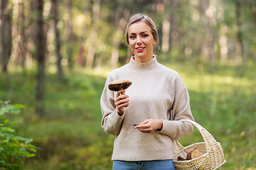 Image showing young woman with mushroom in autumn forest
