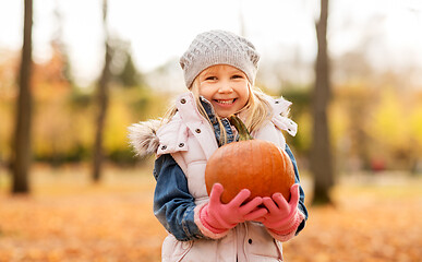 Image showing happy little girl with pumpkin at autumn park