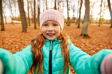 Image showing happy girl taking selfie at autumn park