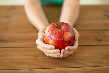 Image showing close up of hands holding ripe red apple