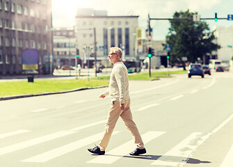 Image showing senior man walking along city crosswalk