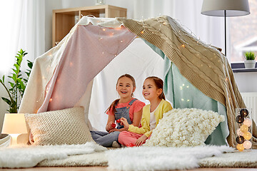 Image showing little girl playing tea party in kids tent at home