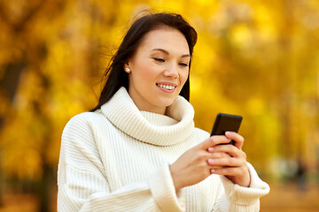 Image showing woman with smartphone in autumn park