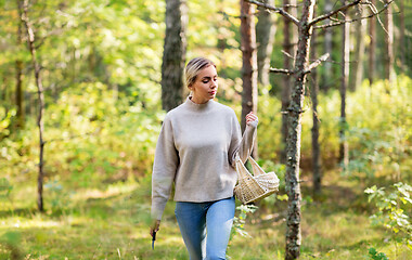 Image showing woman with basket picking mushrooms in forest