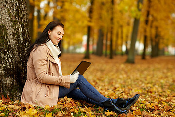 Image showing woman with tablet computer at autumn park