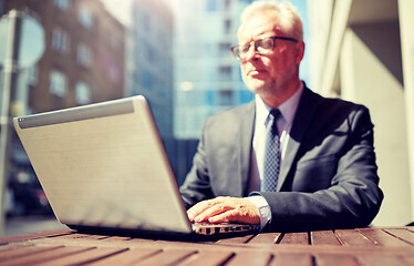 Image showing senior businessman with laptop at outdoor cafe