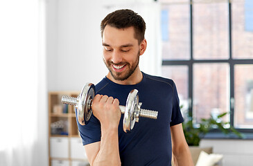 Image showing man exercising with dumbbell at home