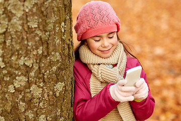 Image showing girl with smartphone at autumn park