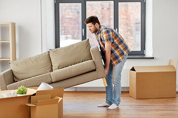 Image showing man moving sofa at new home