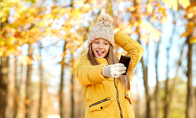 Image showing girl taking selfie by smartphone at autumn park