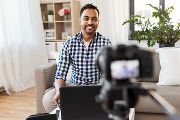 Image showing male blogger with camera videoblogging at home