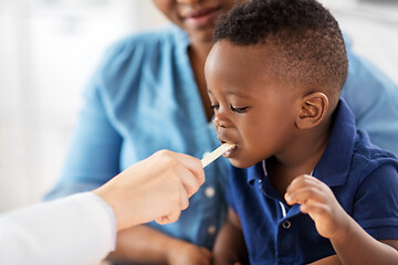 Image showing doctor examining african baby\'s mouth at clinic