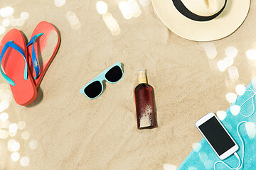 Image showing smartphone, hat, flip flops and shades on beach