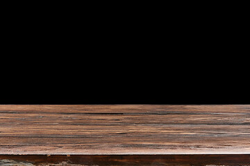 Image showing Oaken table from wooden planks on a black background for display or present your products.