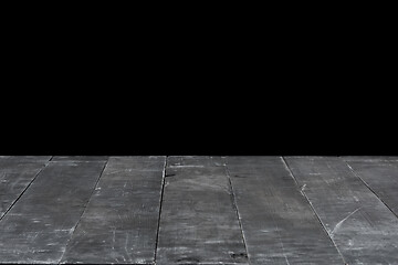 Image showing Dark grey wooden table for expose or montage your products on a black background.