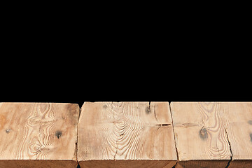 Image showing Wooden table on a black background can used for display or montage your products.