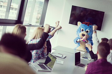 Image showing boss dresed as bear having fun with business people in trendy of