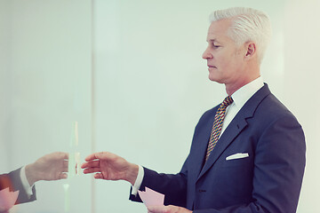 Image showing senior business man making plans with sticker