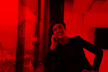 Image showing Elegant Woman Using Mobile Phone by window in office building