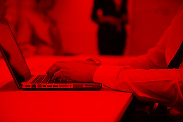 Image showing hands typing on laptop at meeting