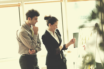 Image showing young couple working on flip board at office