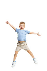 Image showing Adorable boy jumping and raises his hands up.