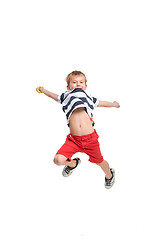 Image showing Adorable boy jumping and raises his hands up.