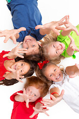 Image showing Close-up of happy children lying on floor in studio and looking up