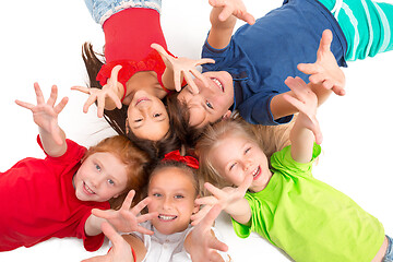 Image showing Close-up of happy children lying on floor in studio and looking up