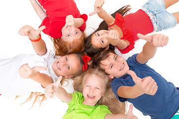 Image showing Close-up of happy children lying on floor in studio and looking up