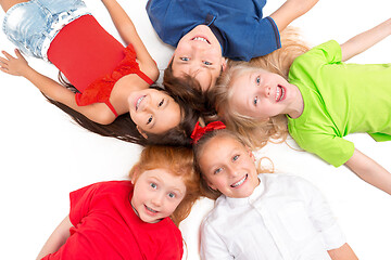 Image showing Close-up of happy children lying on floor in studio and looking up