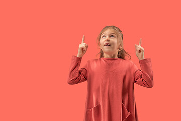 Image showing Cute little surprised girl in coral dress with long hair smiling to camera