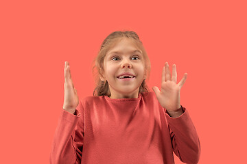 Image showing Cute little surprised girl in coral dress with long hair smiling to camera